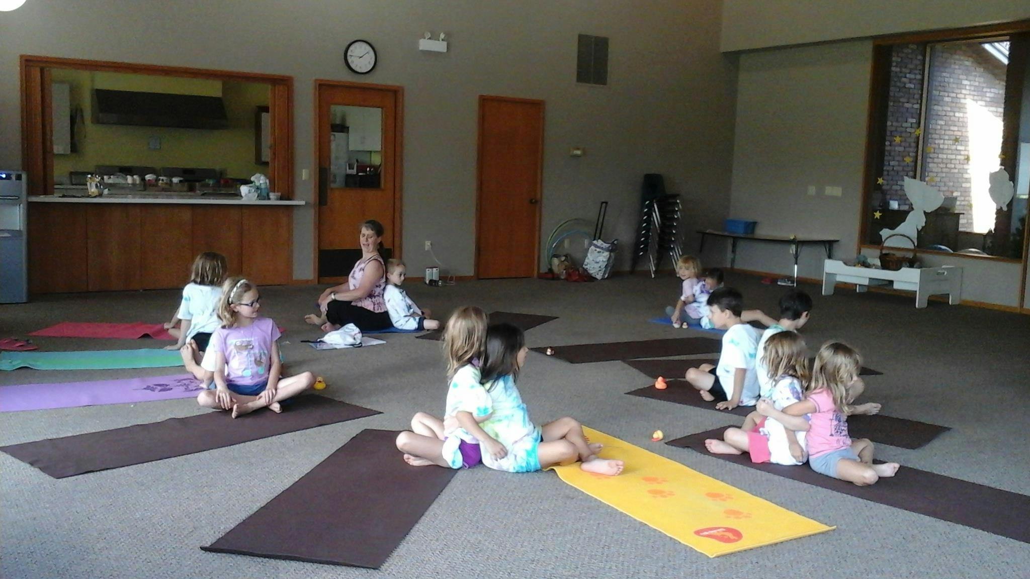 Children sitting on yoga mats in a room