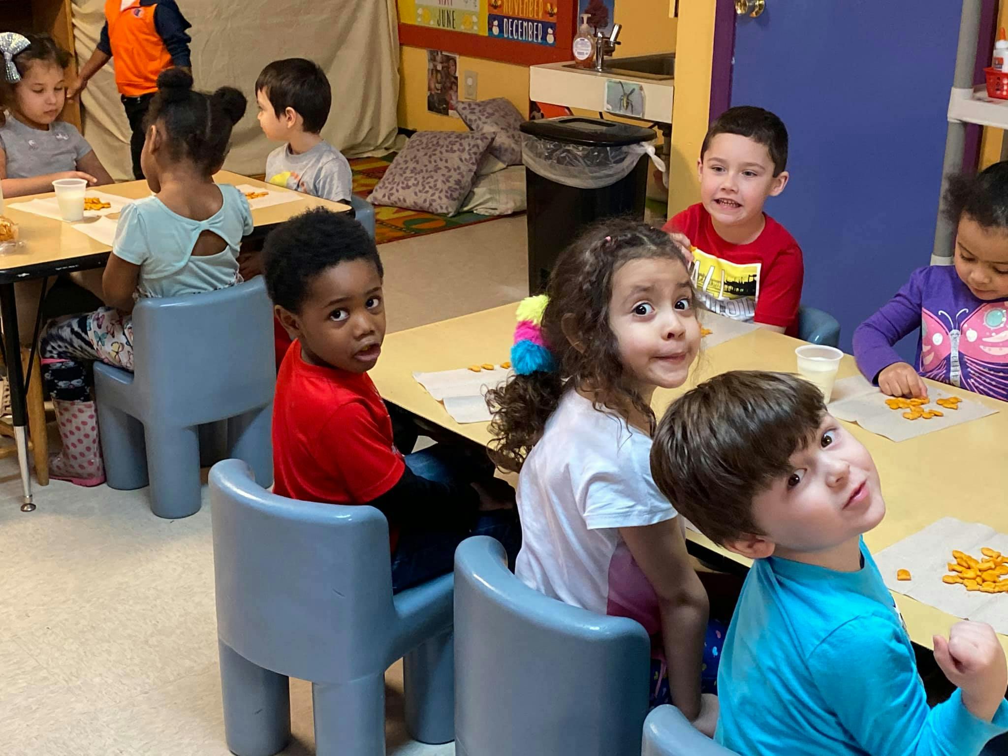 Children sitting at tables in a classroom