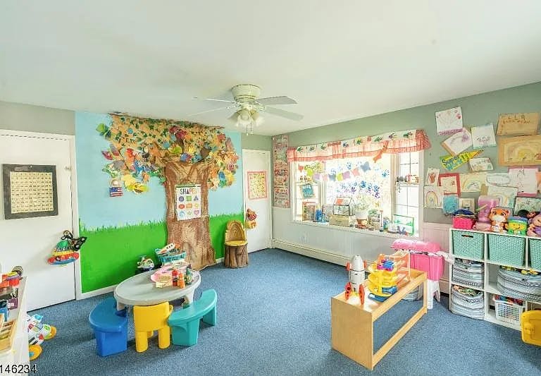 Playroom with a tree mural, small table and chairs, and toys
