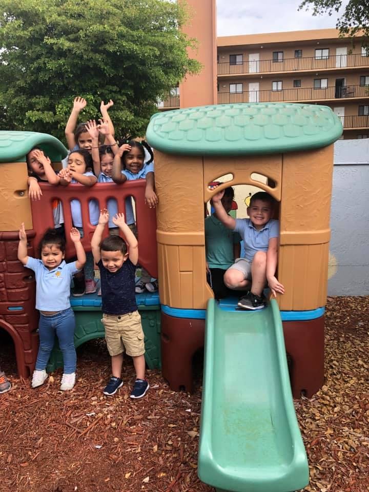 Children playing on a colorful outdoor play structure with a slide