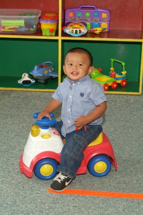 Child sitting on a toy ride-on car