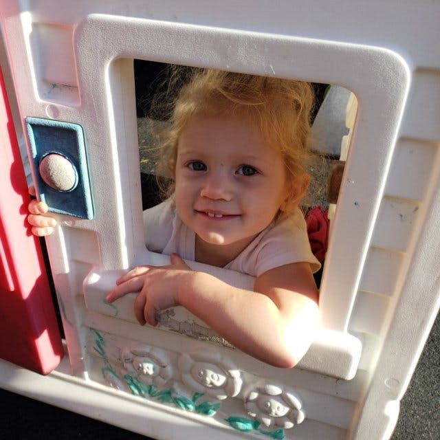 Child looking out of a playhouse window