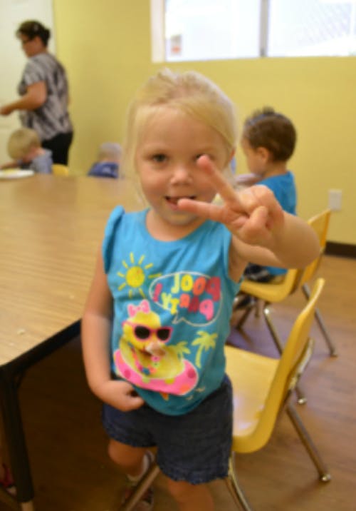 Child making a peace sign with their hand