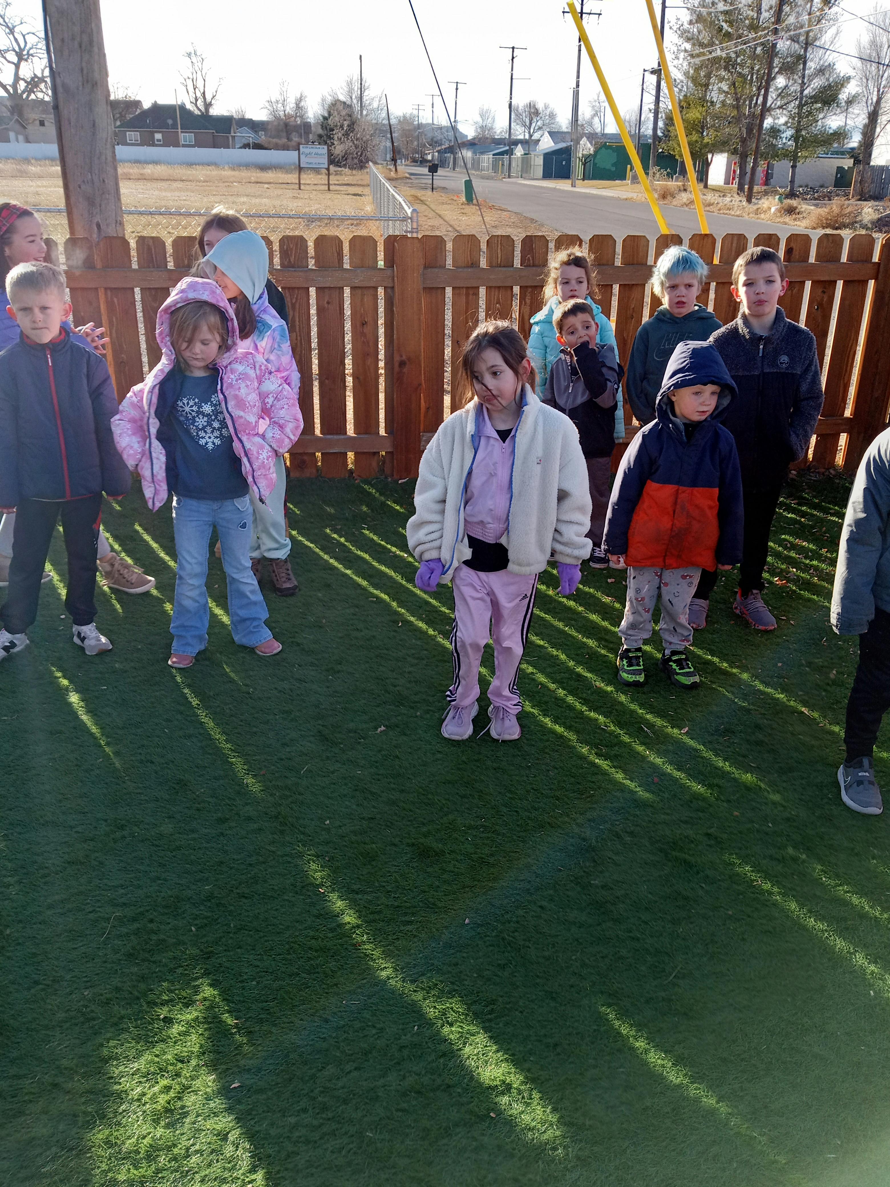 Group of children standing on artificial grass outdoors