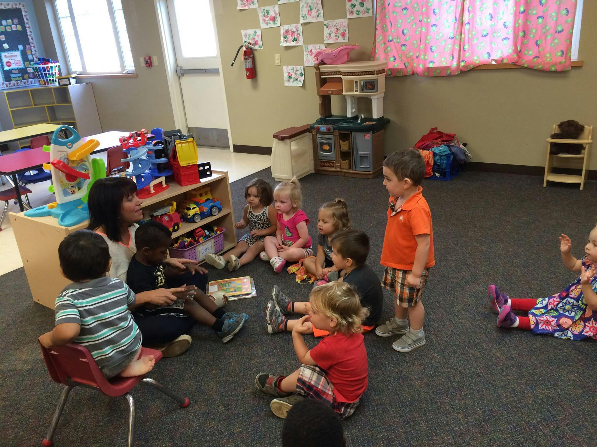 Adult and children sitting on floor in a classroom