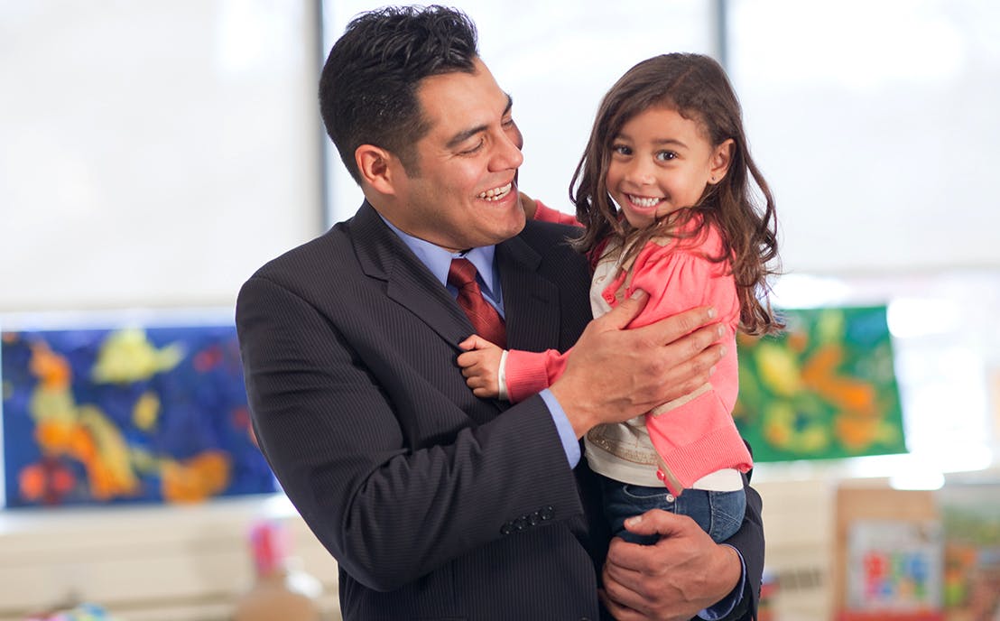 Person in suit holding a child