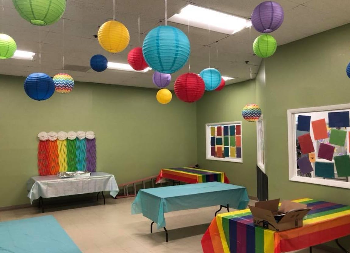 Room decorated with colorful paper lanterns and tables with tablecloths