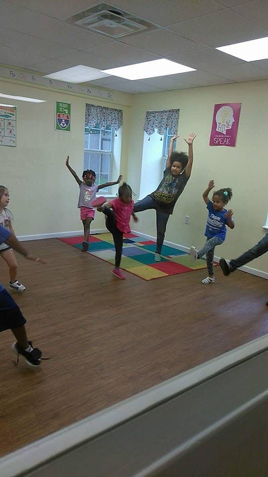 Children in a room stretching and posing