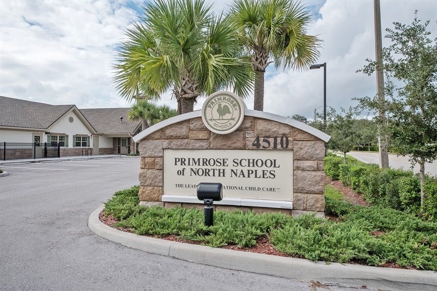 Stone sign for Primrose School of North Naples with palm trees