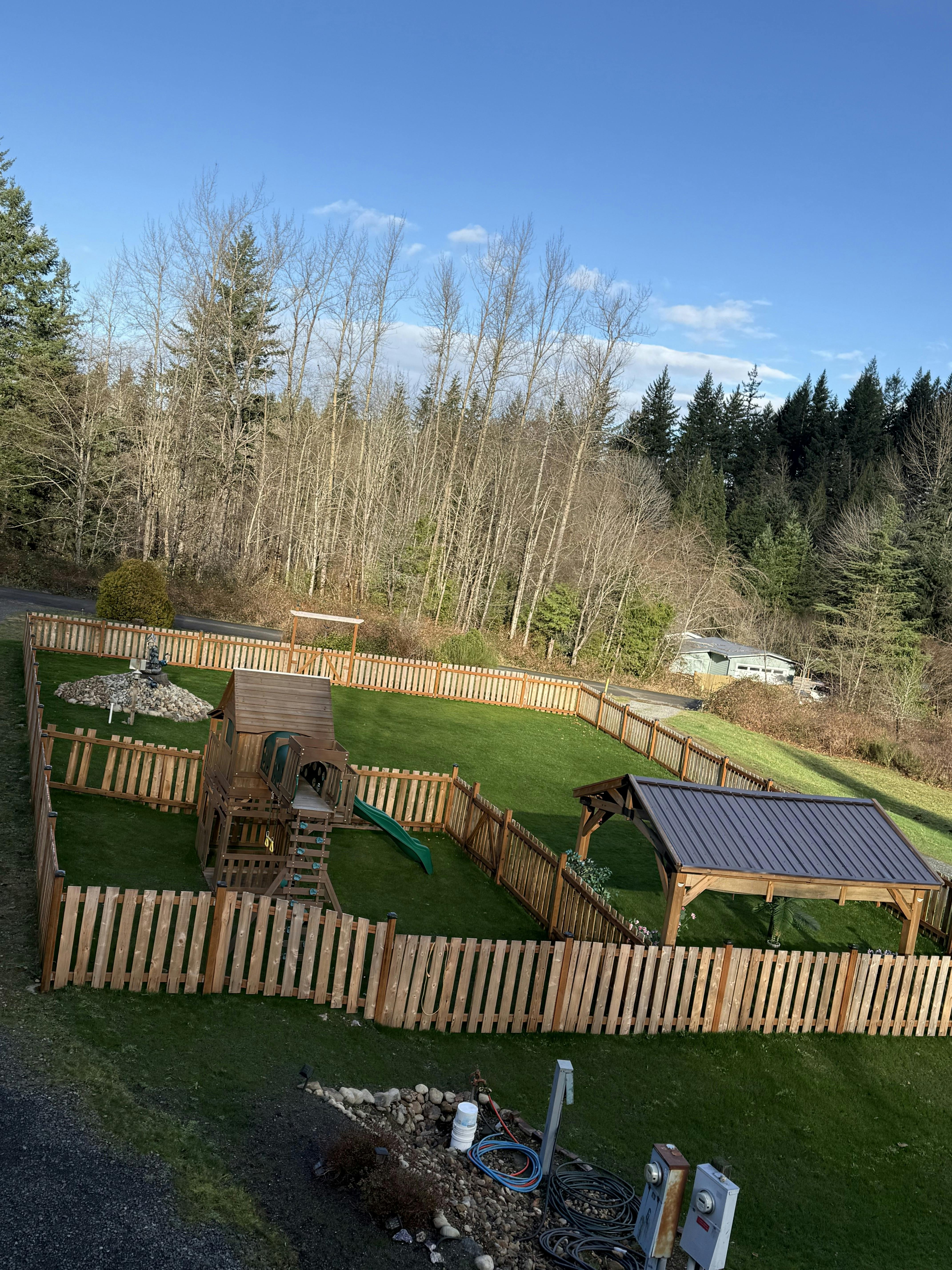 backyard with a wooden play structure and a covered seating area