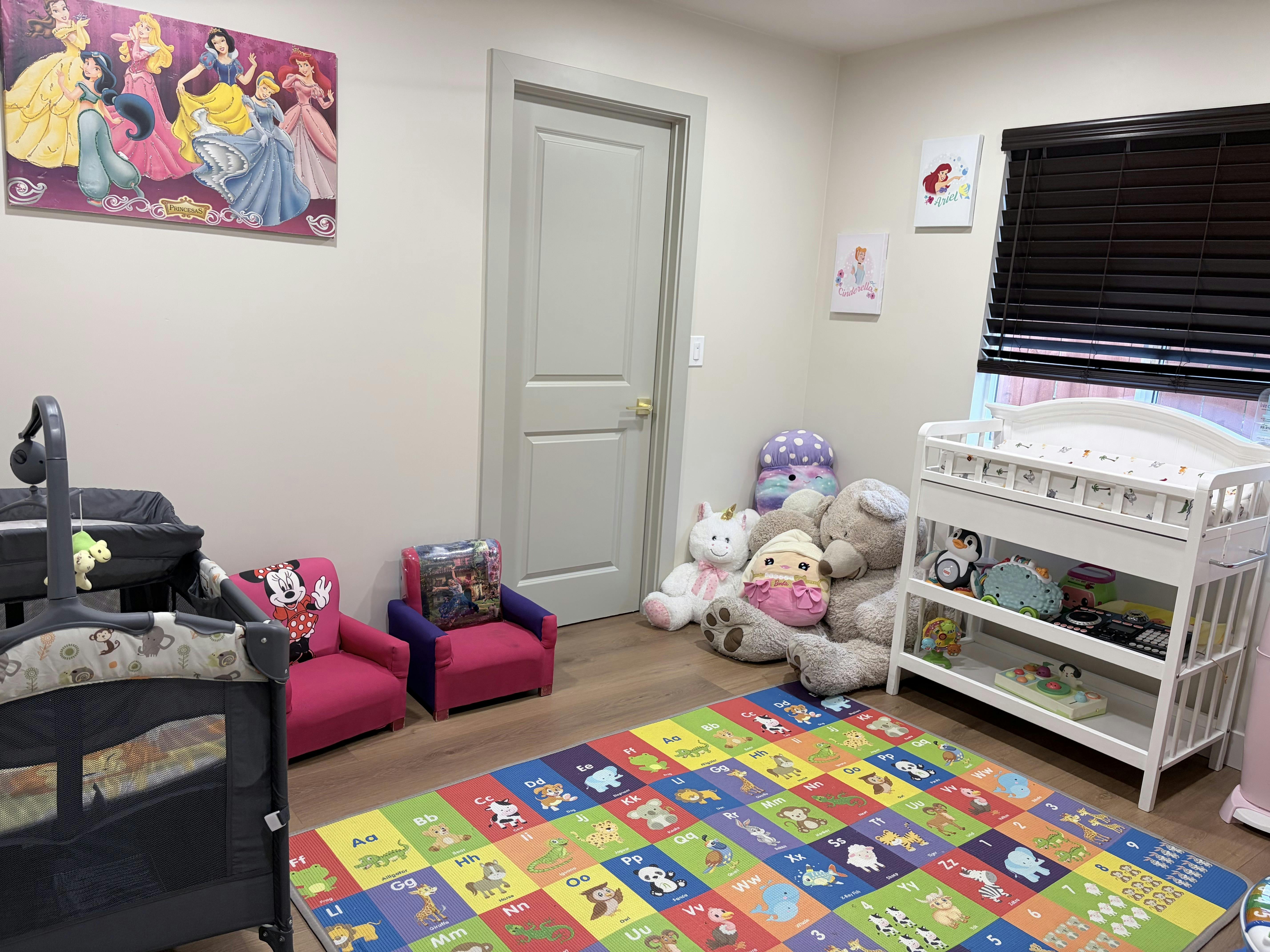 Child bedroom with alphabet floor mat, stuffed toys, and furniture