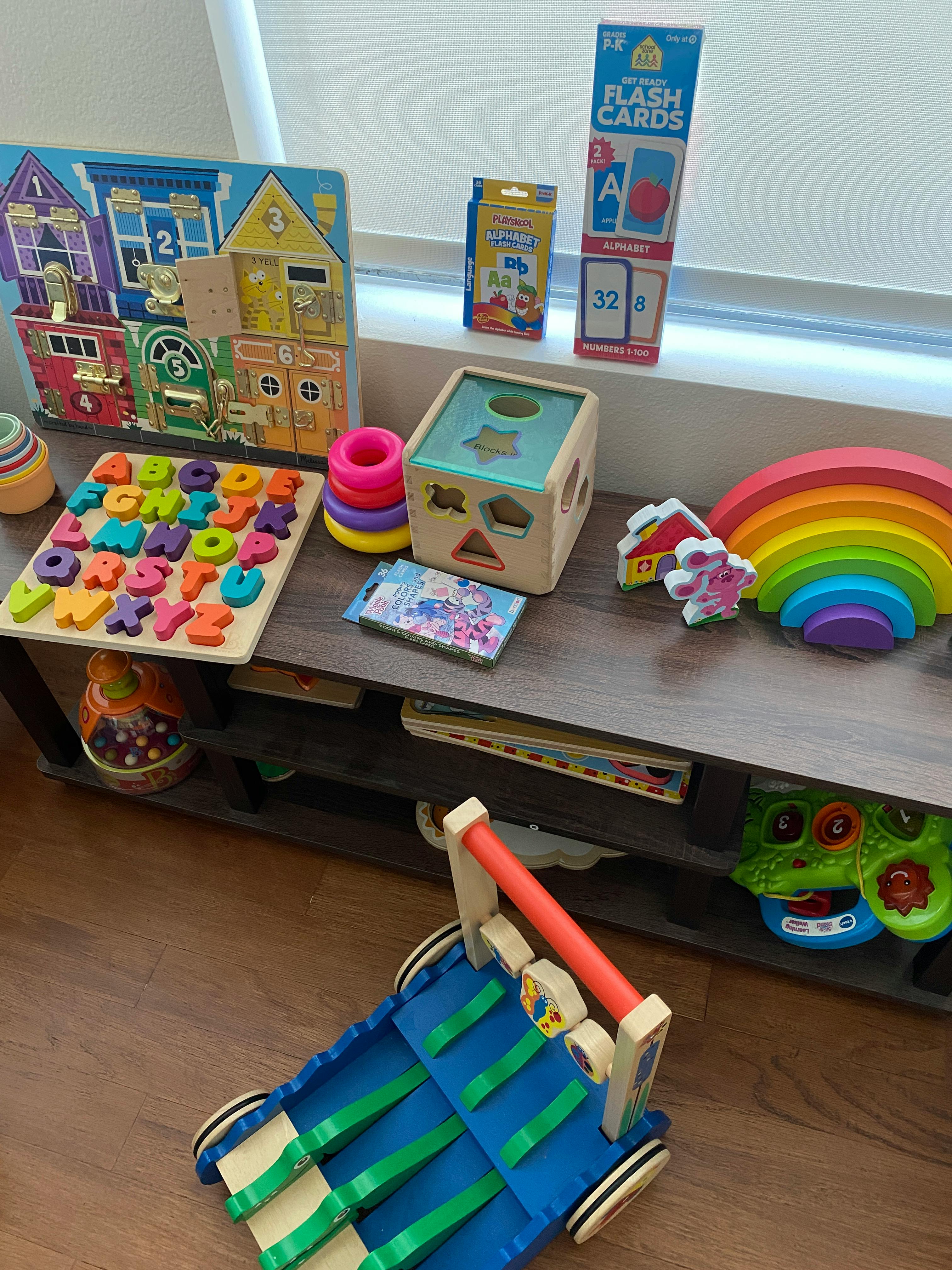 Assortment of children's toys including puzzles, blocks, and a rainbow stacker