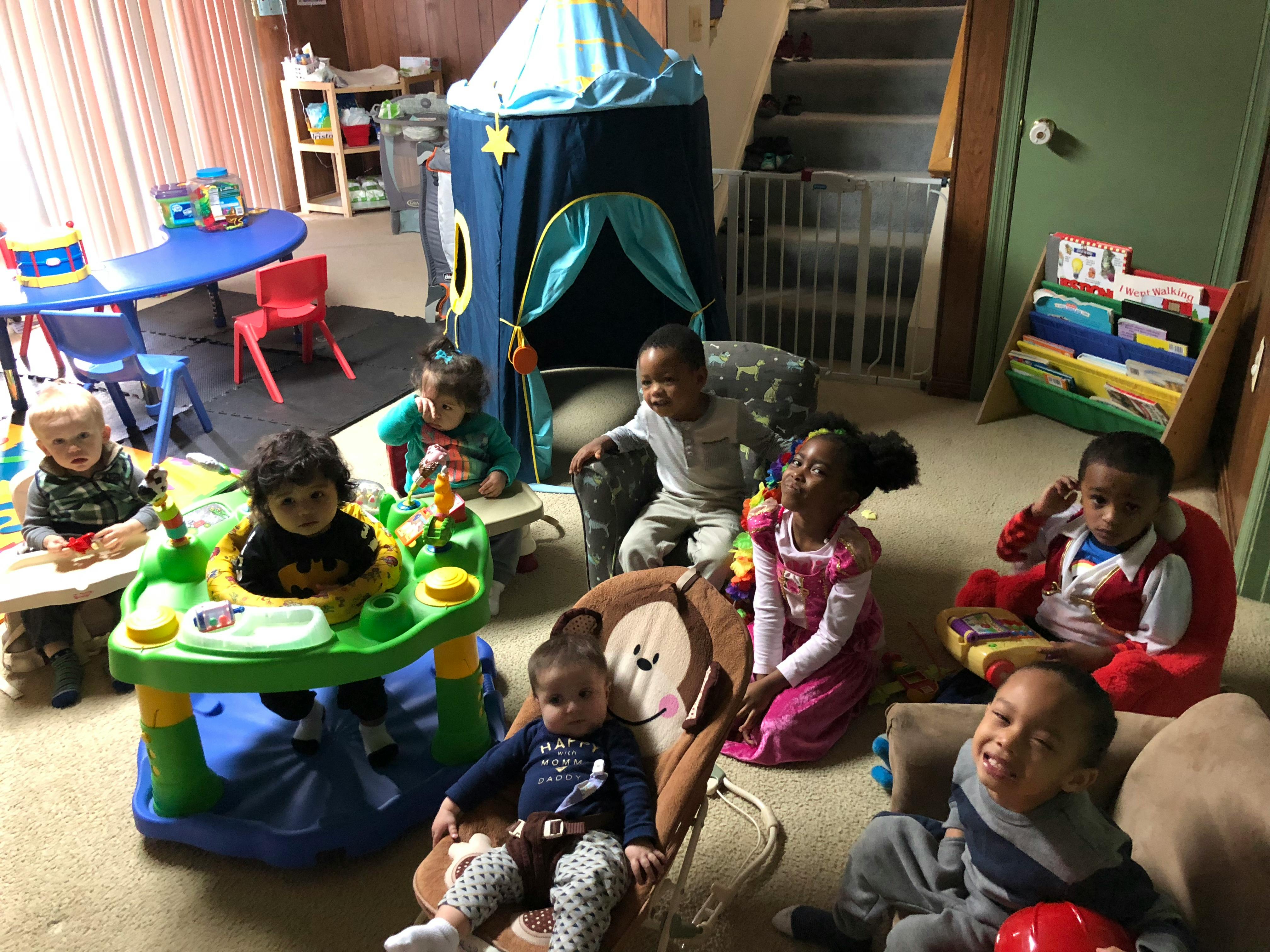 Multiple children playing in a room with toys and play structures