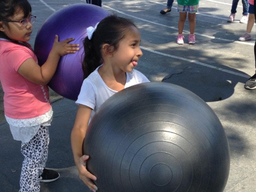 Two children holding large exercise balls