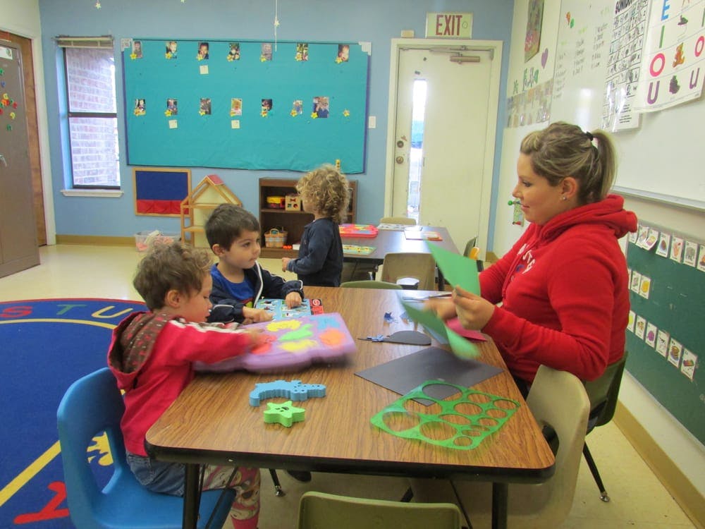 Adult and children at a table in a classroom