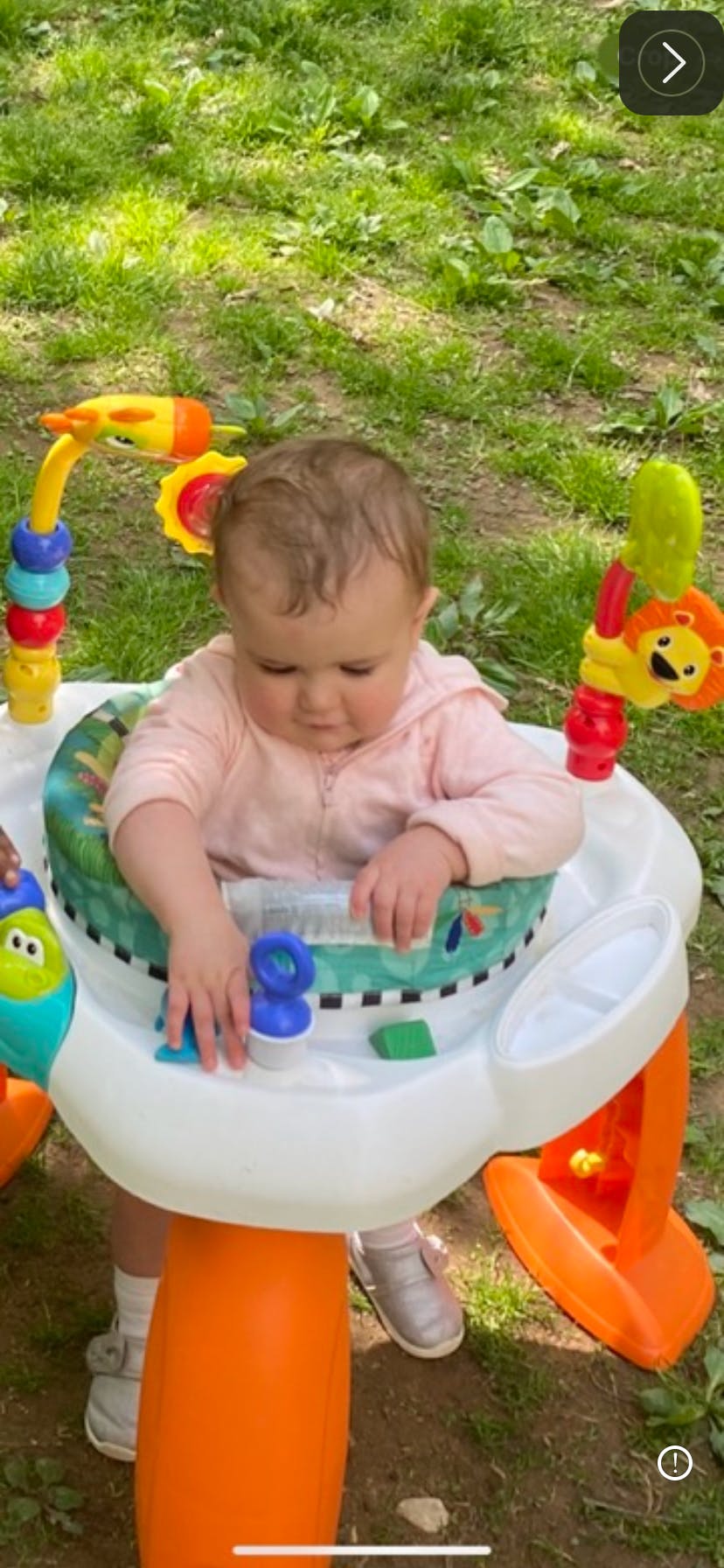 Child in a baby activity center outdoors
