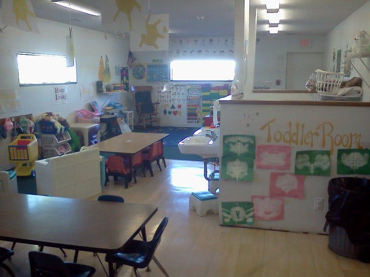 Toddler room with small tables and chairs, a sink, and decorations
