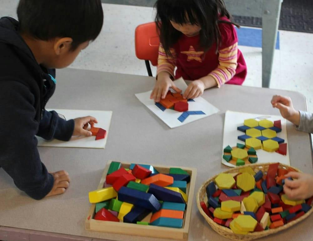 Children playing with colorful wooden blocks at a table