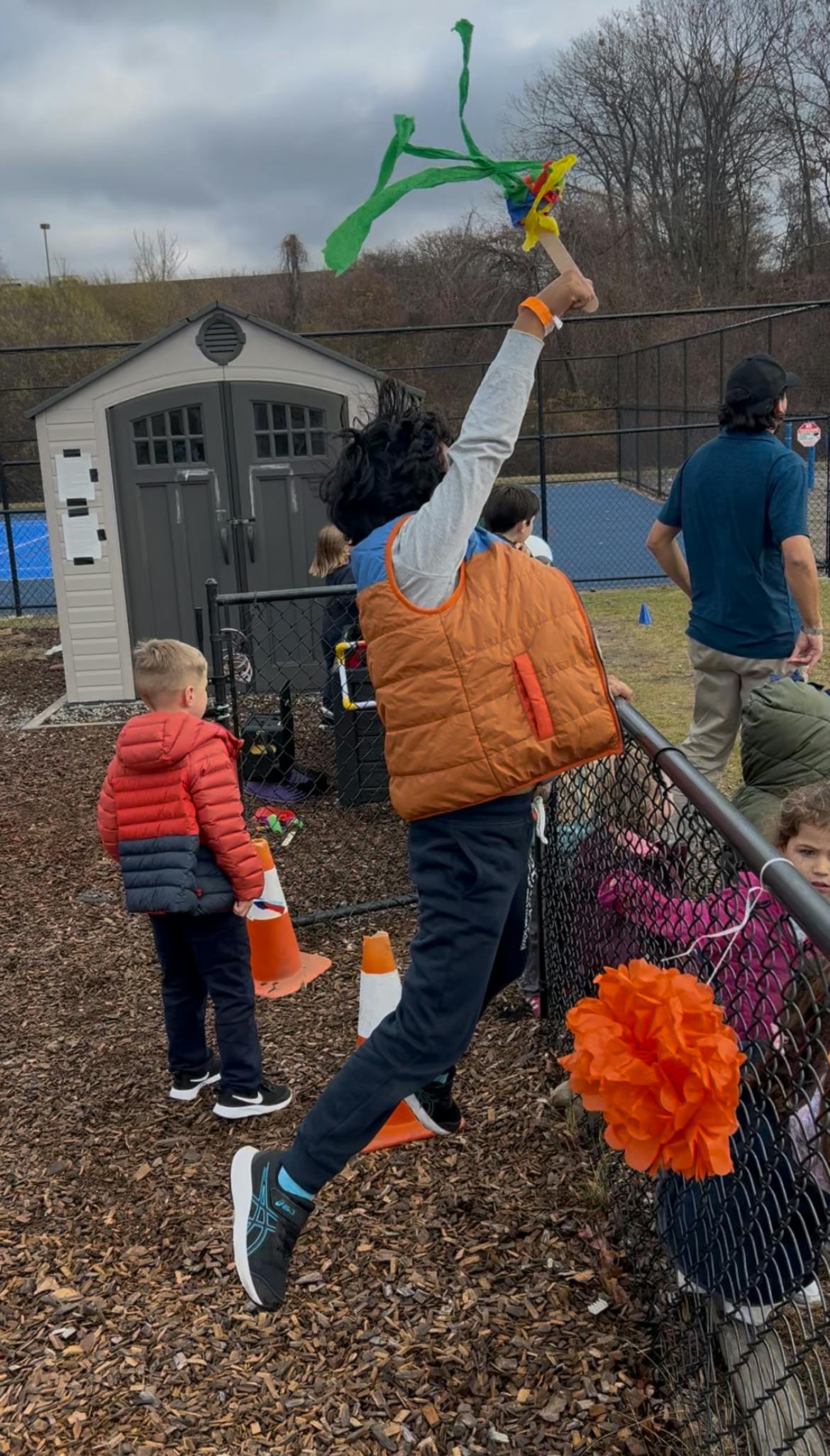 Person holding up colorful streamers on a stick outside