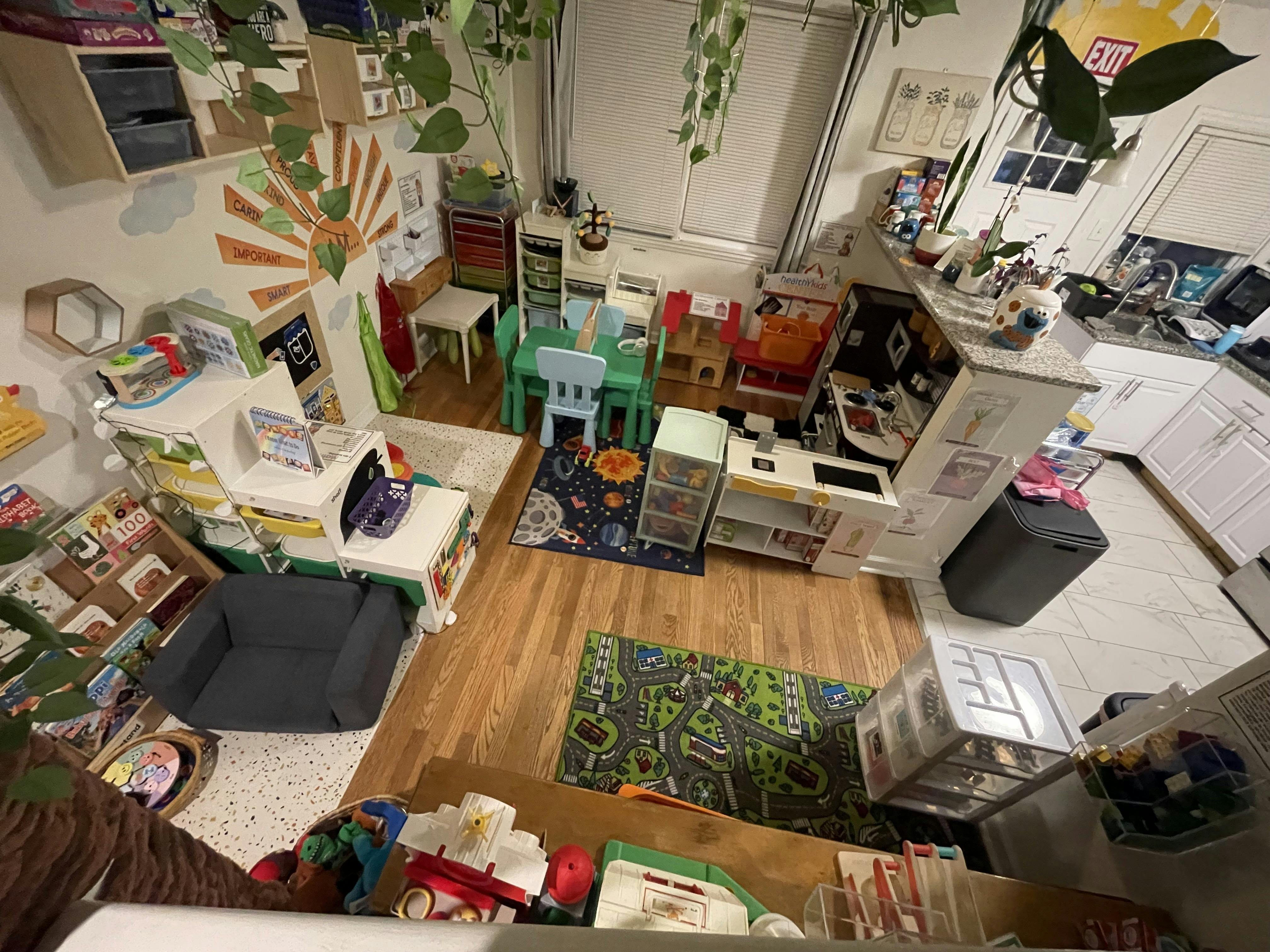 Playroom with small tables, chairs, and toys on a wooden floor