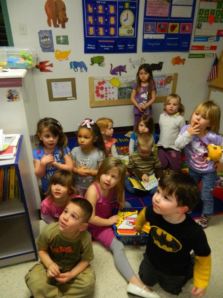 Group of children sitting and standing in a classroom