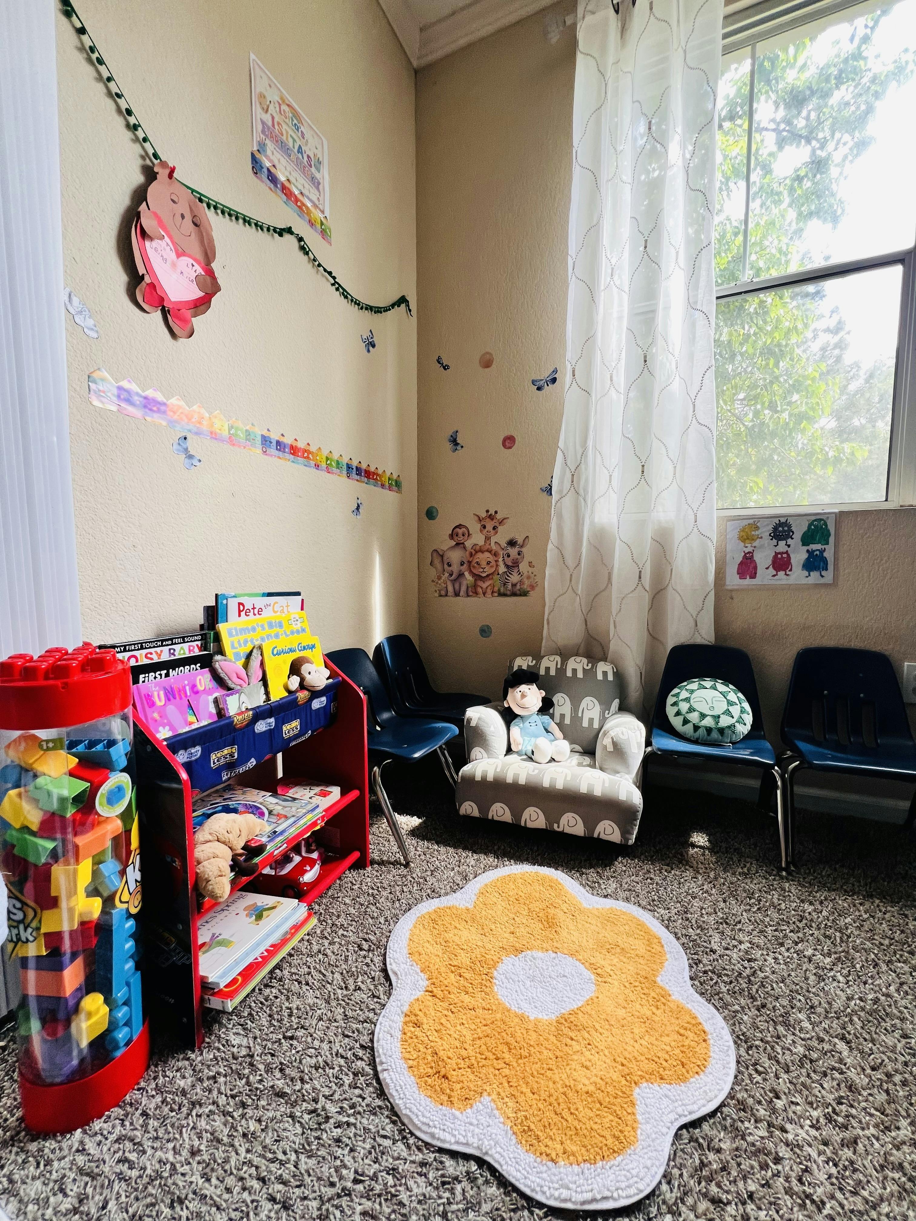 Children's corner with a bookshelf, small chairs, and a window