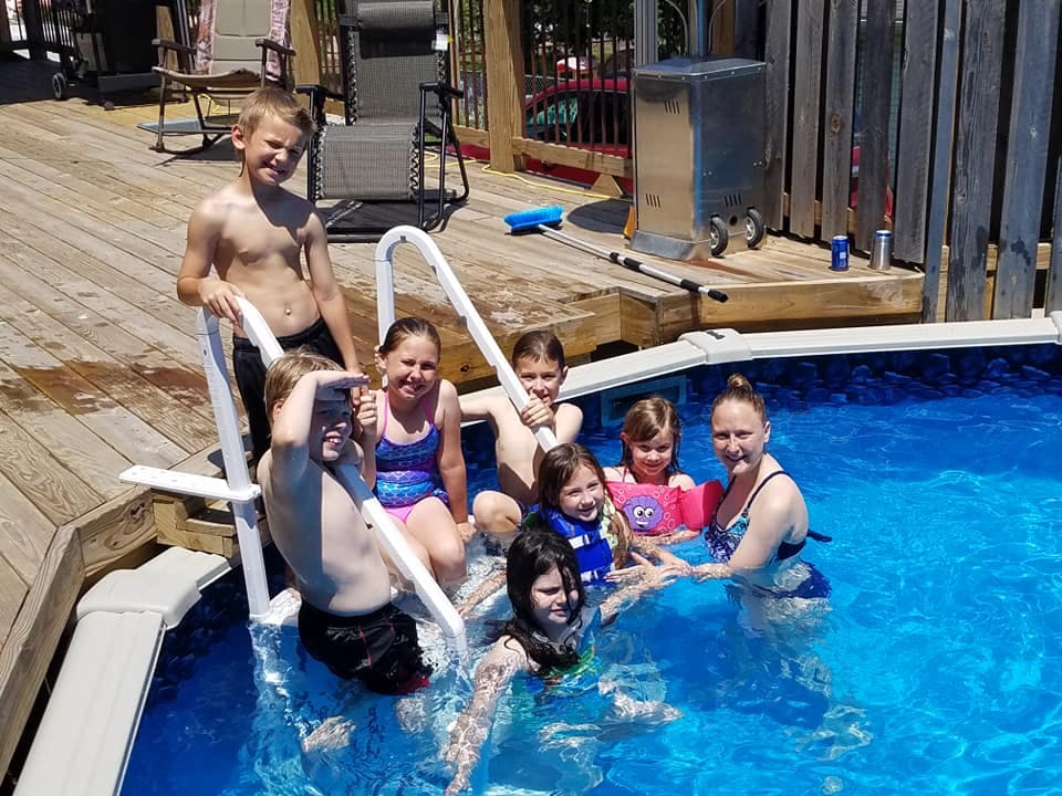 Group of children and one adult in a swimming pool