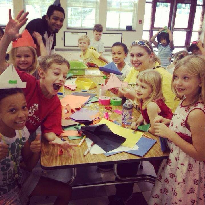 Adults and children at a table with craft supplies
