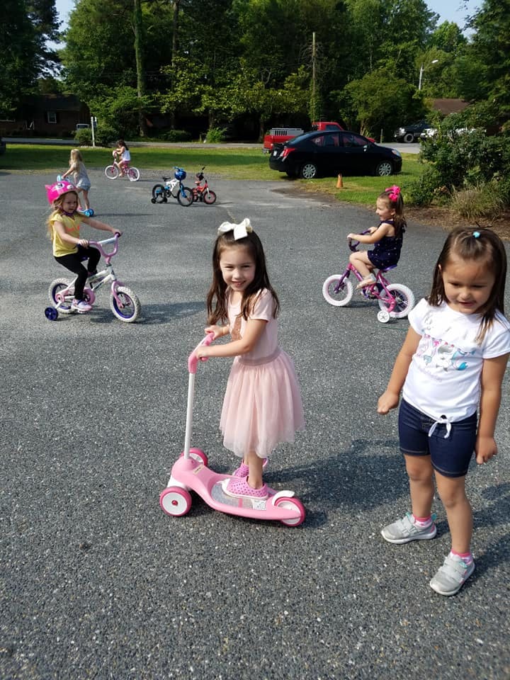 Children riding bikes and scooters outdoors