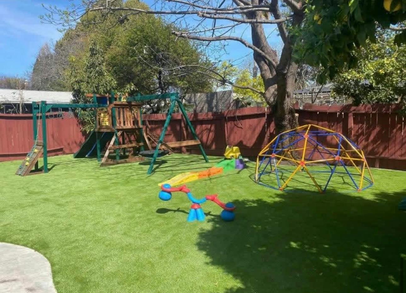 Backyard playground with a climbing frame, swing set, and climbing dome
