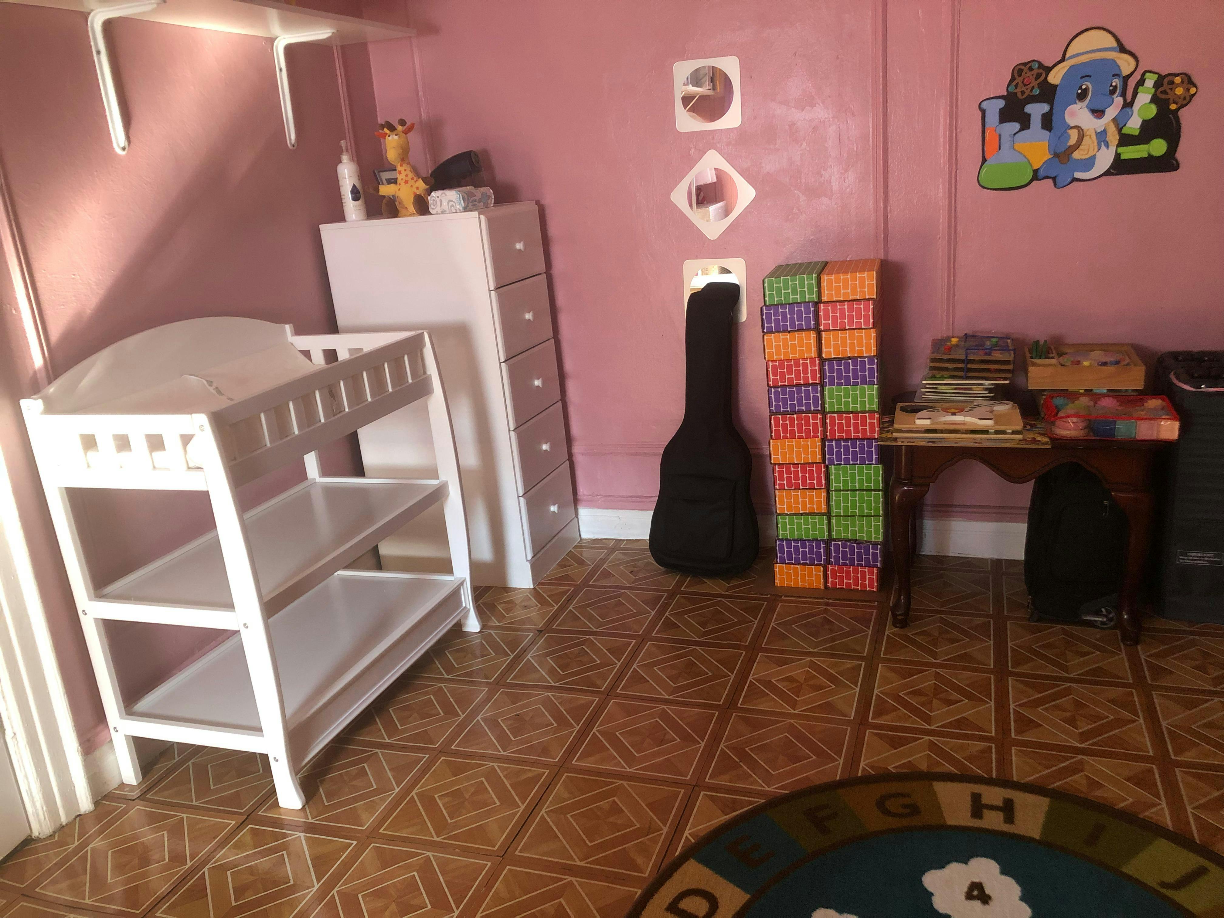 Changing table in a room with a guitar case and colorful mats