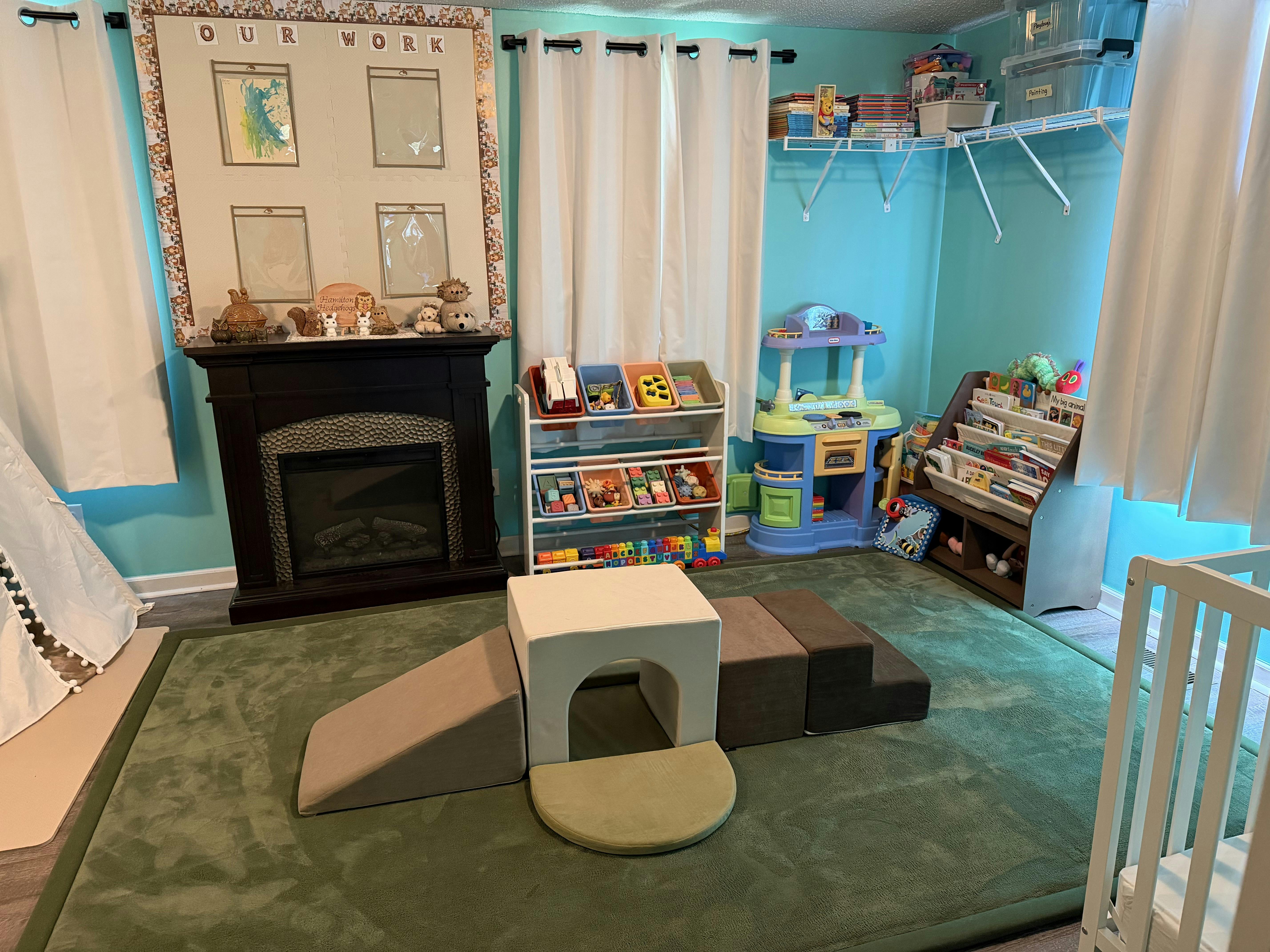 Playroom with soft climbing blocks, toy storage, and fireplace
