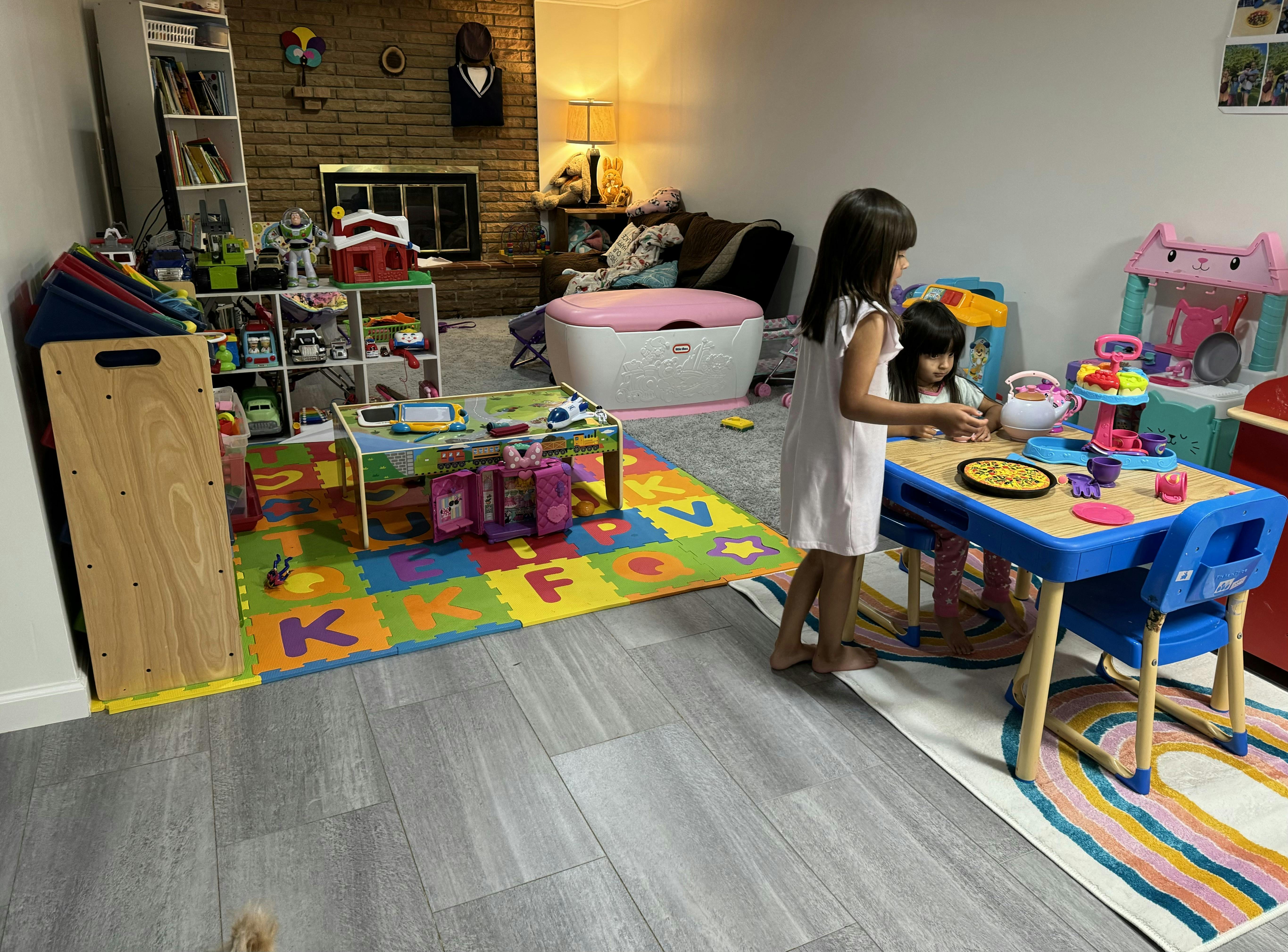 Two children playing with toys at a small table