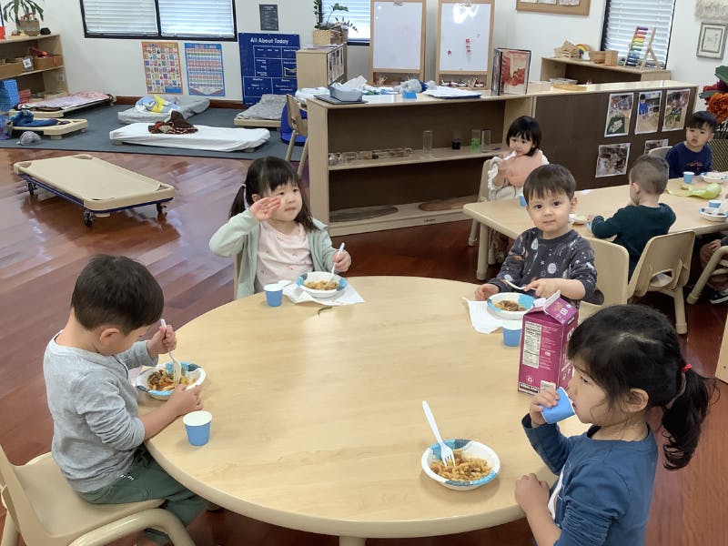 Children eating at tables in a classroom