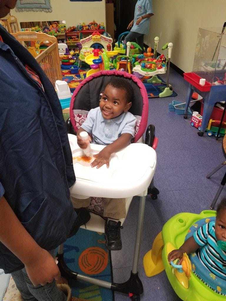 Child in a high chair with food on the tray