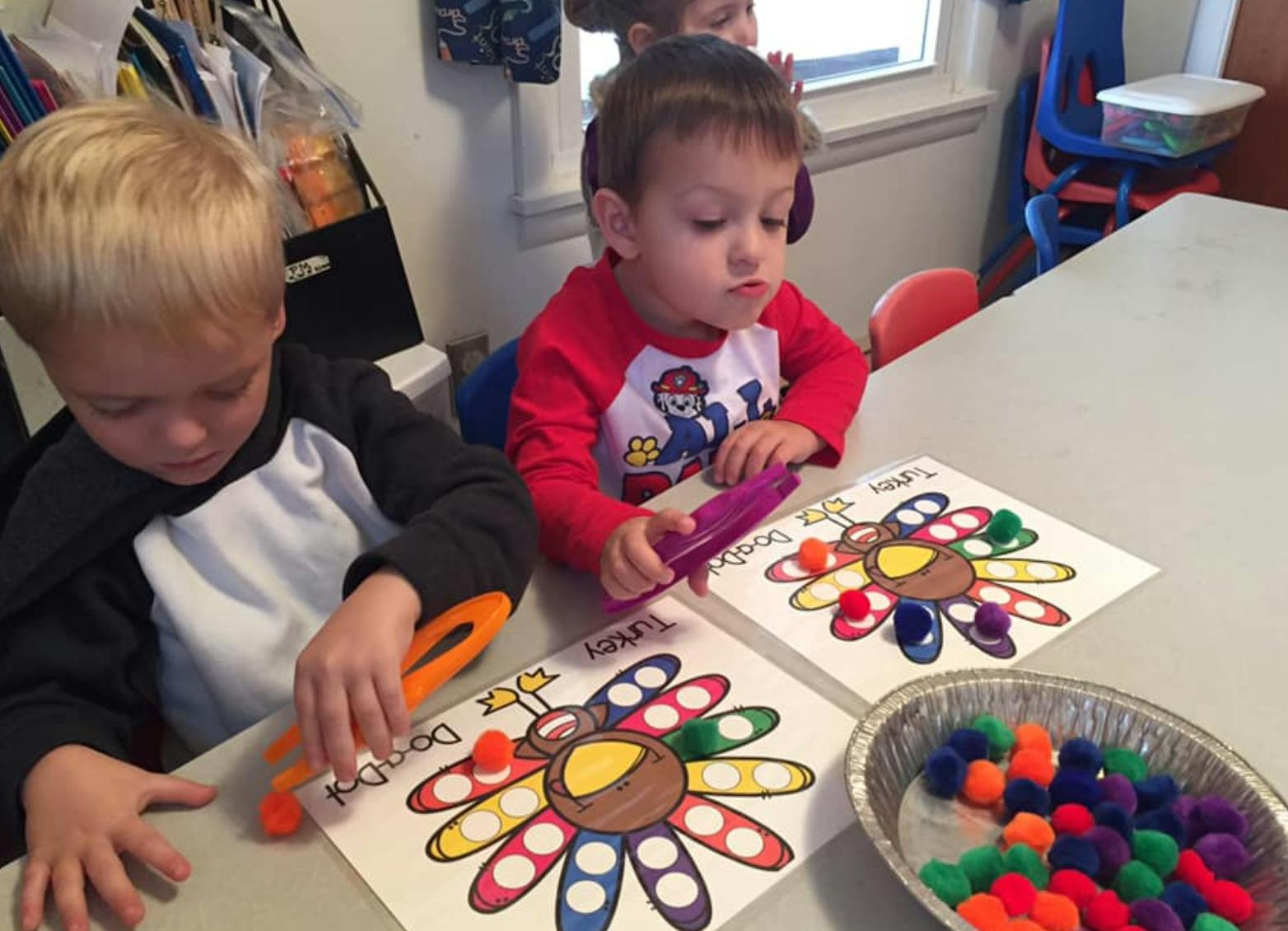 Two children doing an art activity at a table