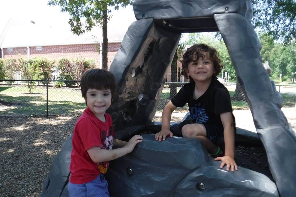 Two children on a playground climbing structure