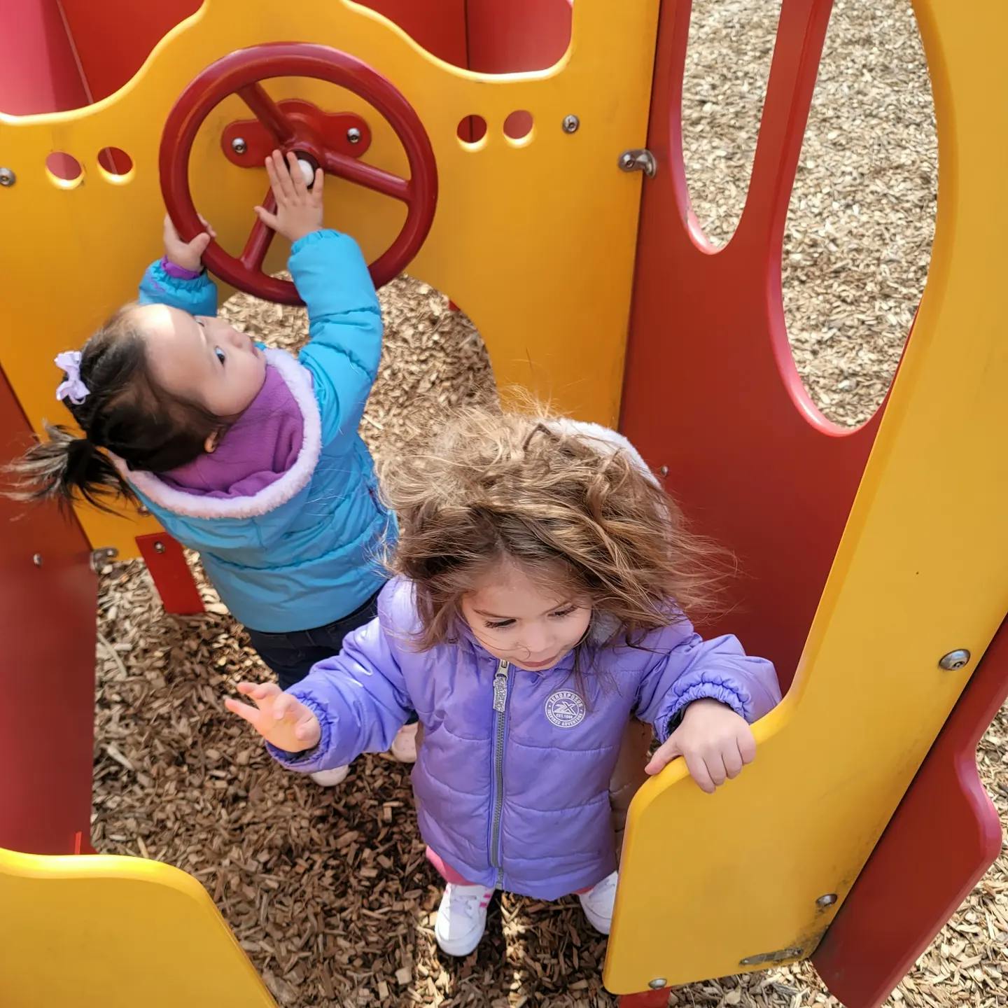 Two children playing on a playground structure