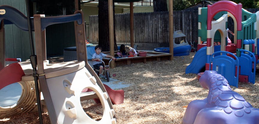 Children playing on playground equipment and in a sandbox