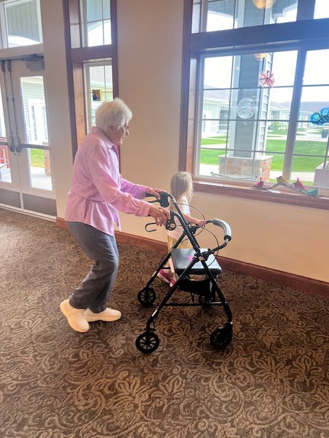 Person using a walker with a child sitting in it