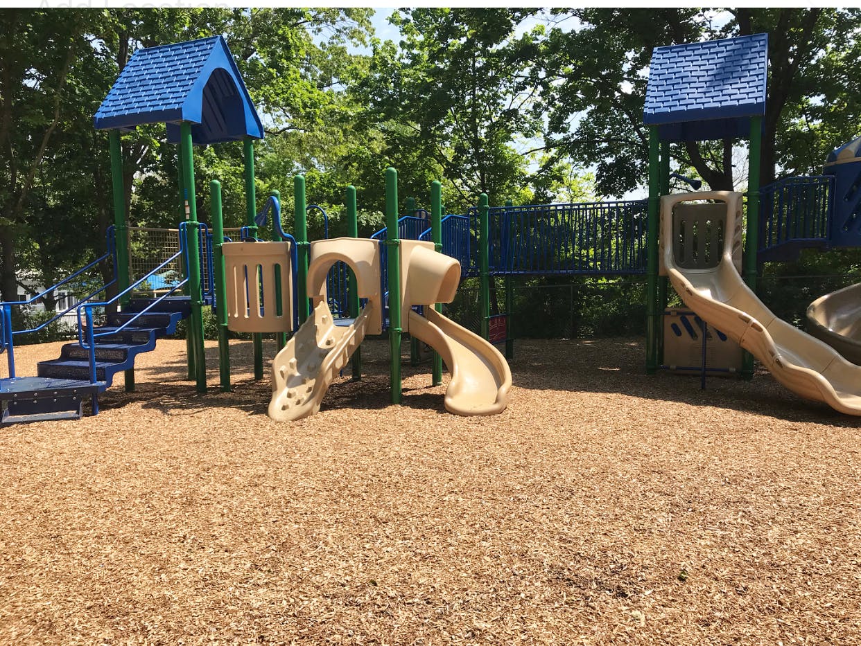 Playground with slides and climbing structures on wood chips