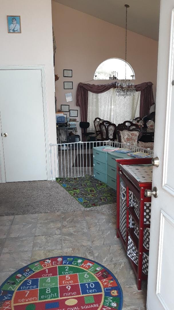 Room with child gate and a colorful rug with numbers and letters