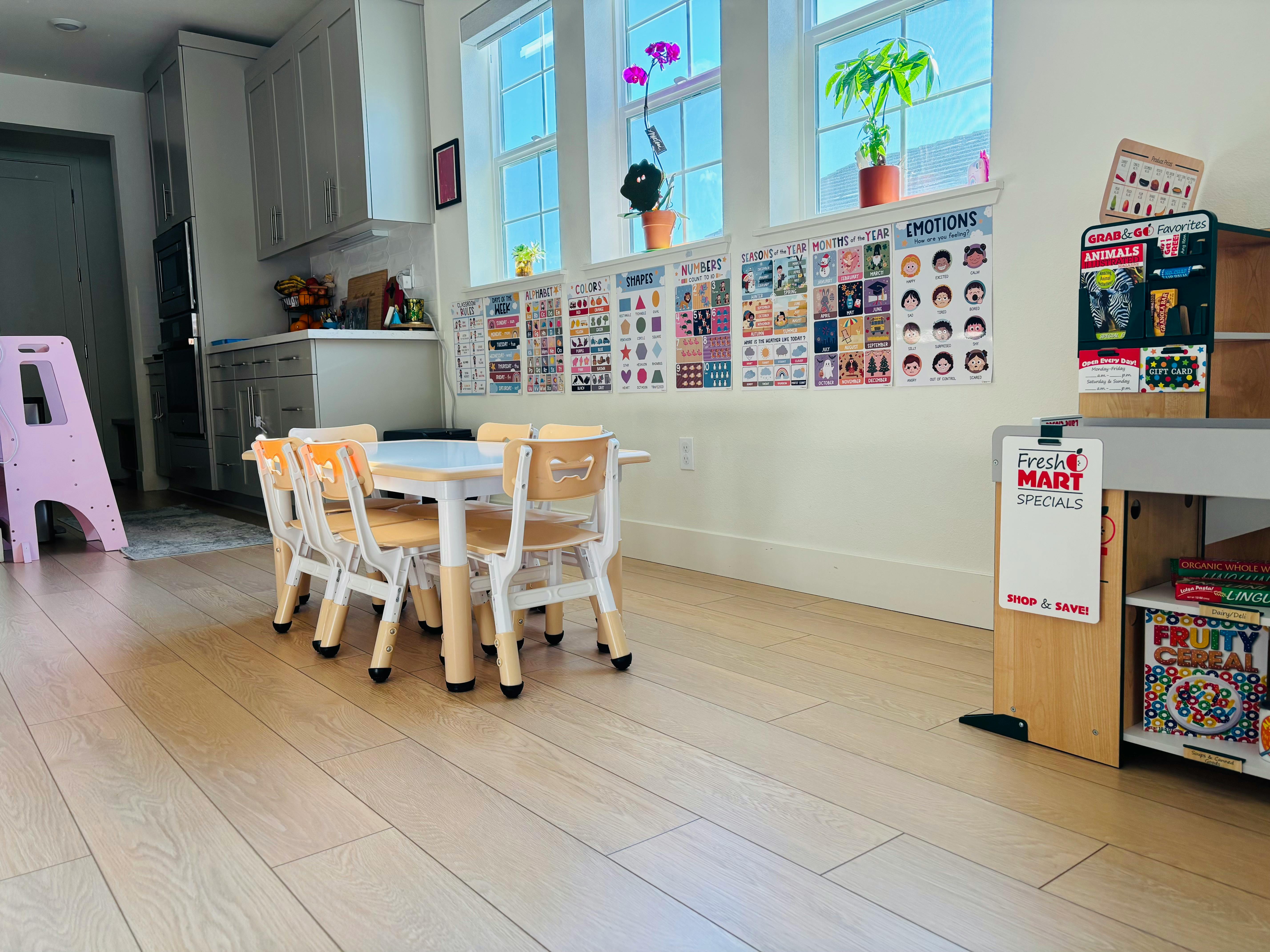 Small table and chairs in a room with windows and posters on the wall