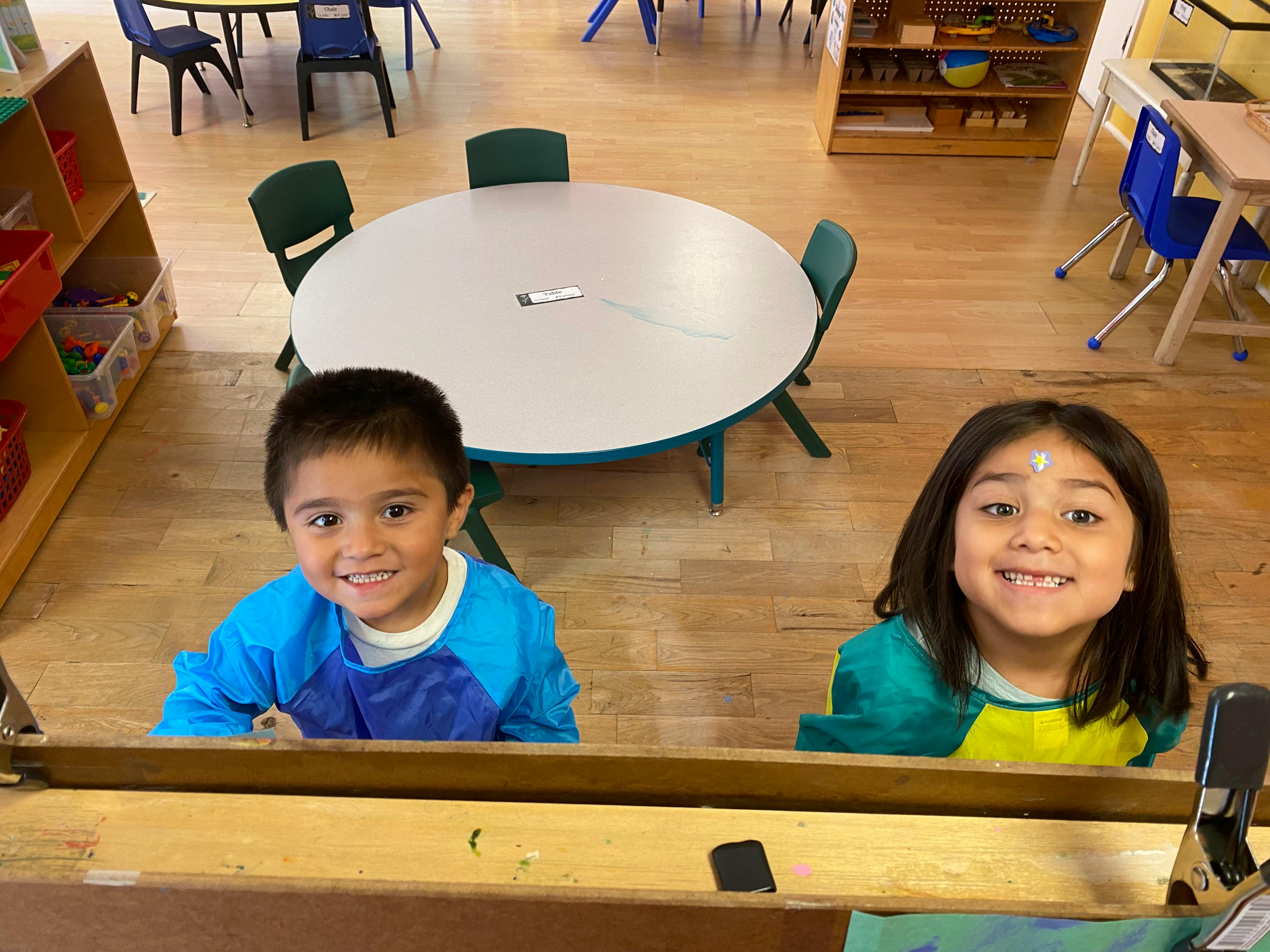 Two children smiling in a classroom
