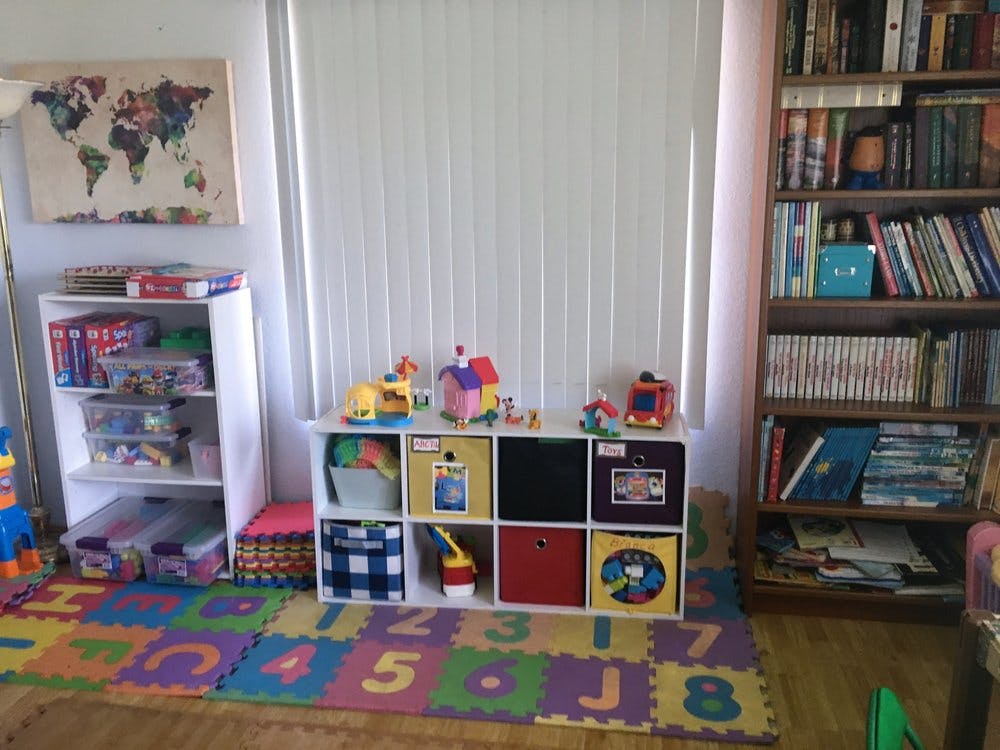 Playroom with toy storage, bookshelf, and alphabet mat