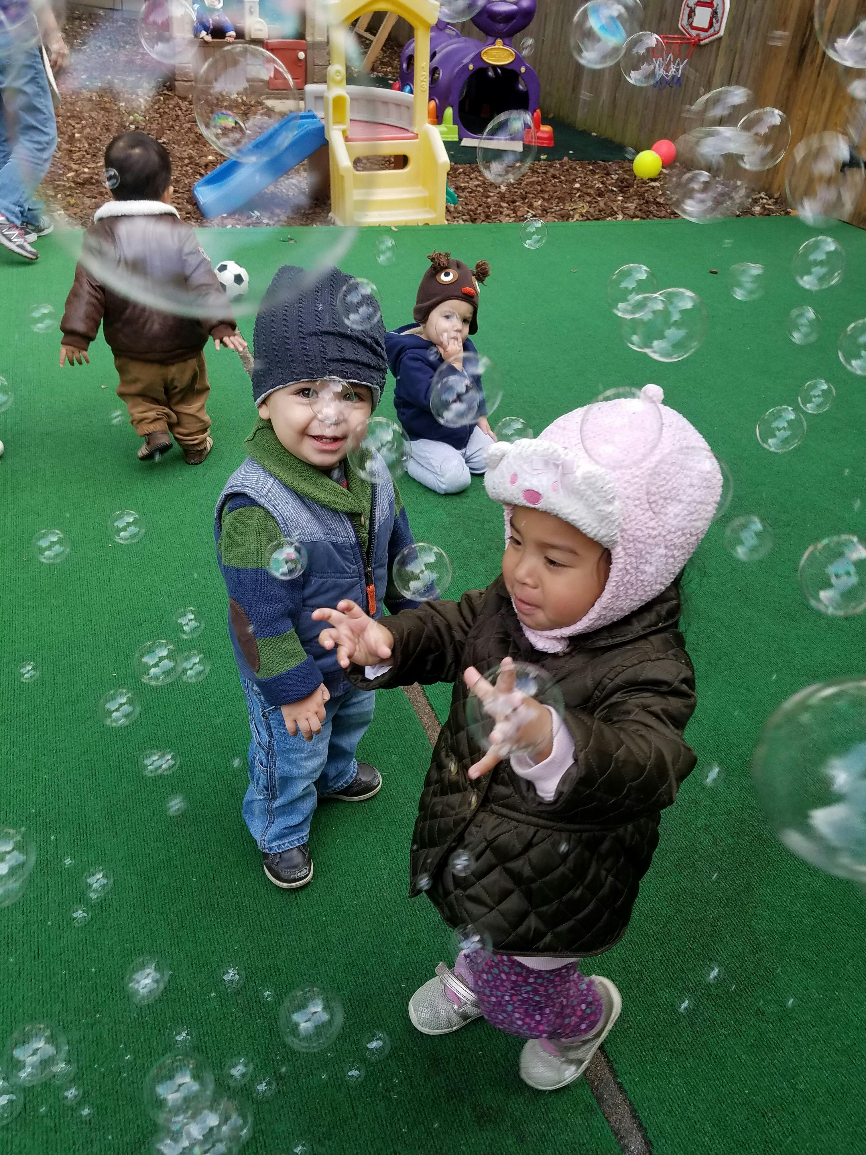 Children playing with bubbles outdoors