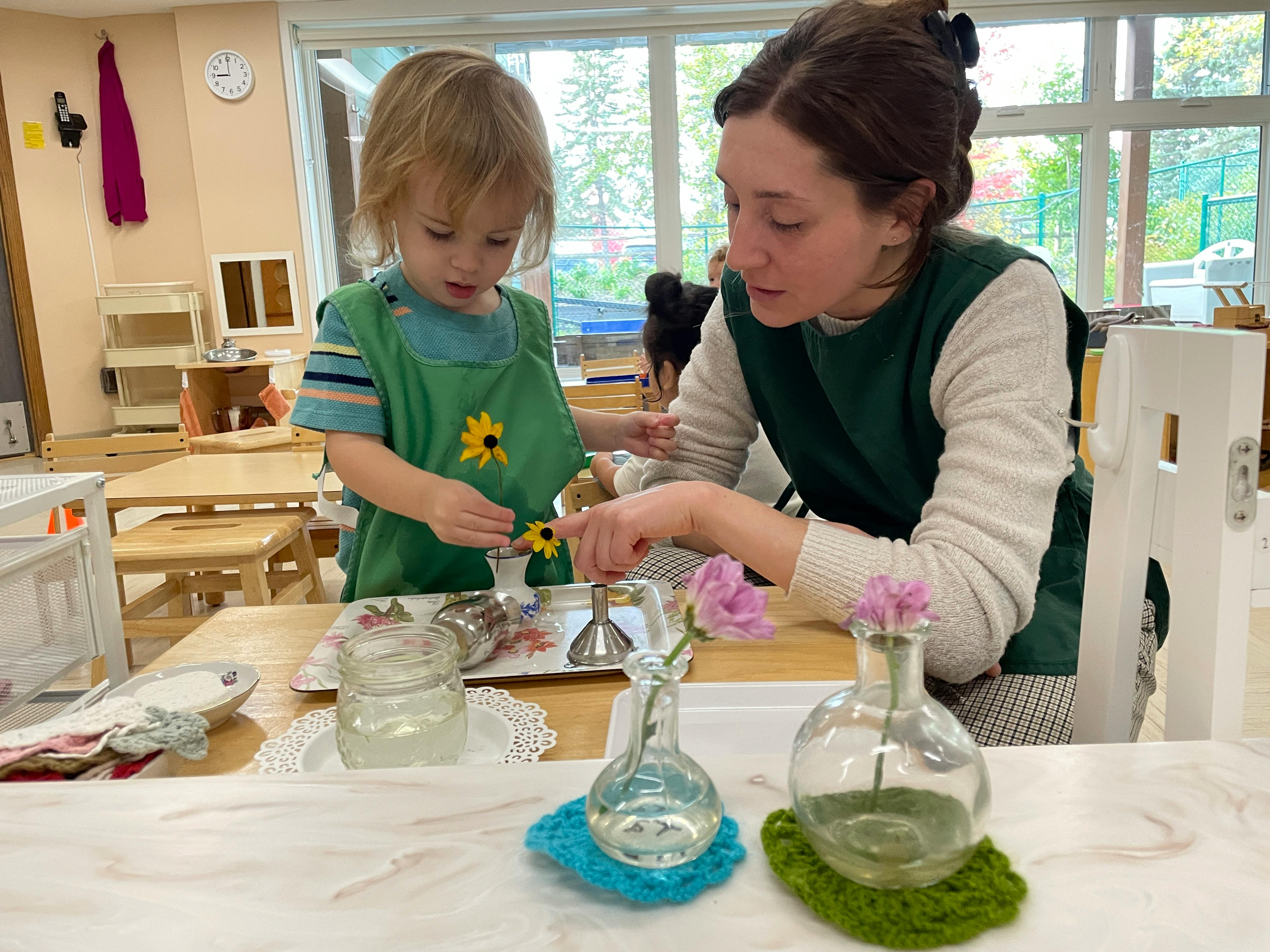 Adult and child arranging flowers at a table