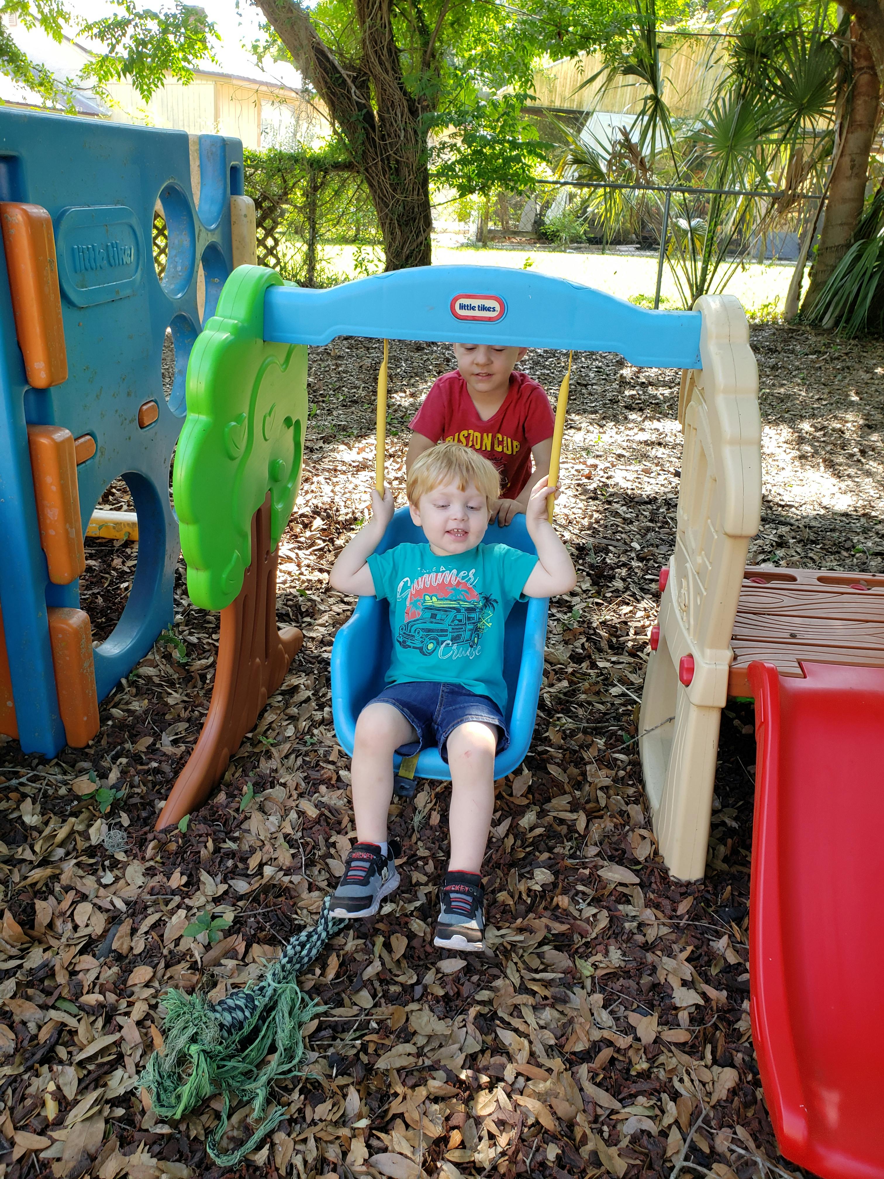 Two children on a playground swing set