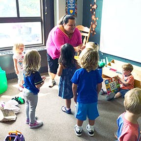 Adult interacting with children in a classroom