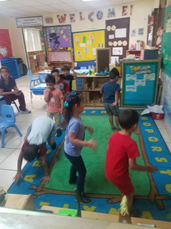 Children playing on a rug in a classroom